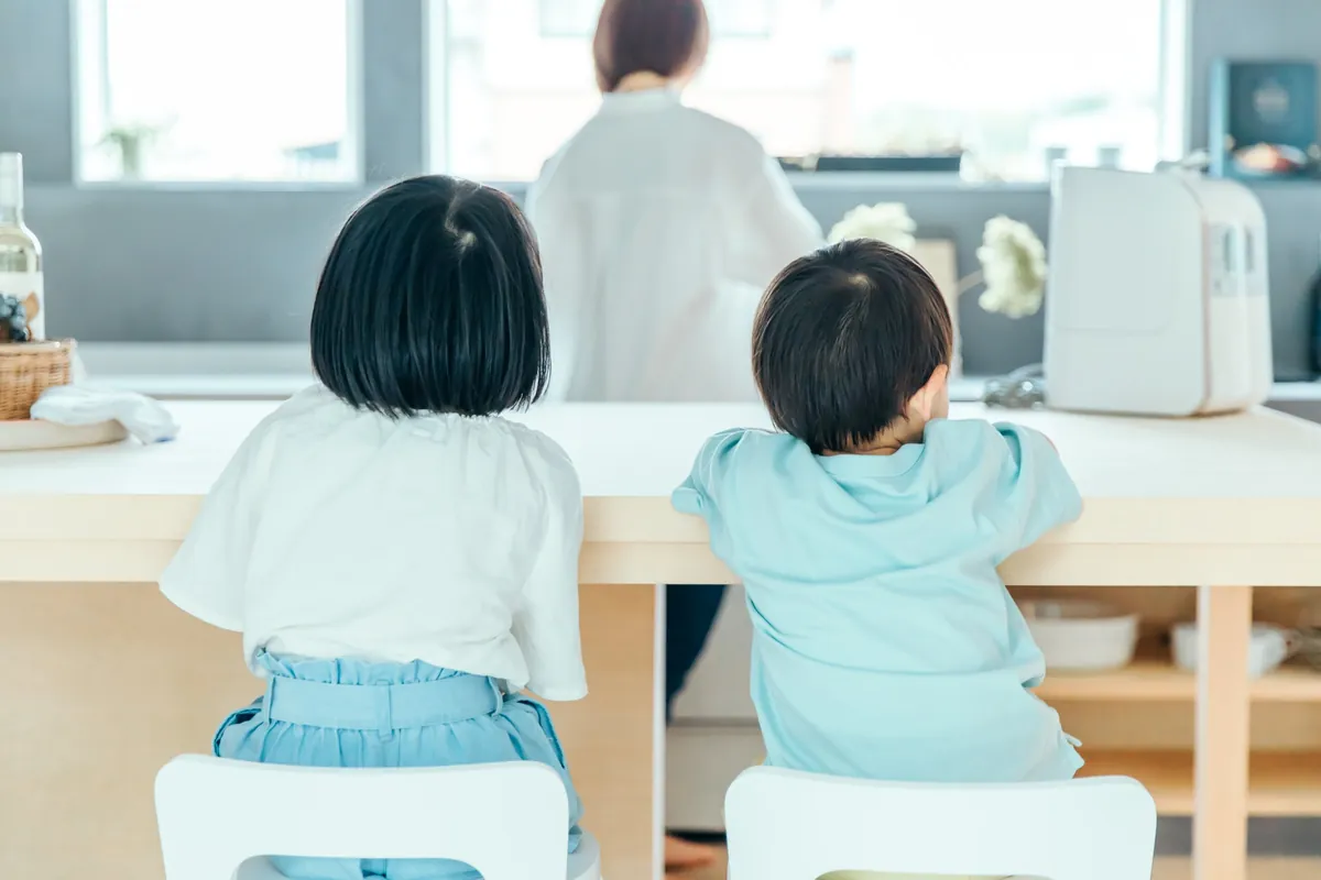 カウンターに座ってお母さんを見る子どもたち