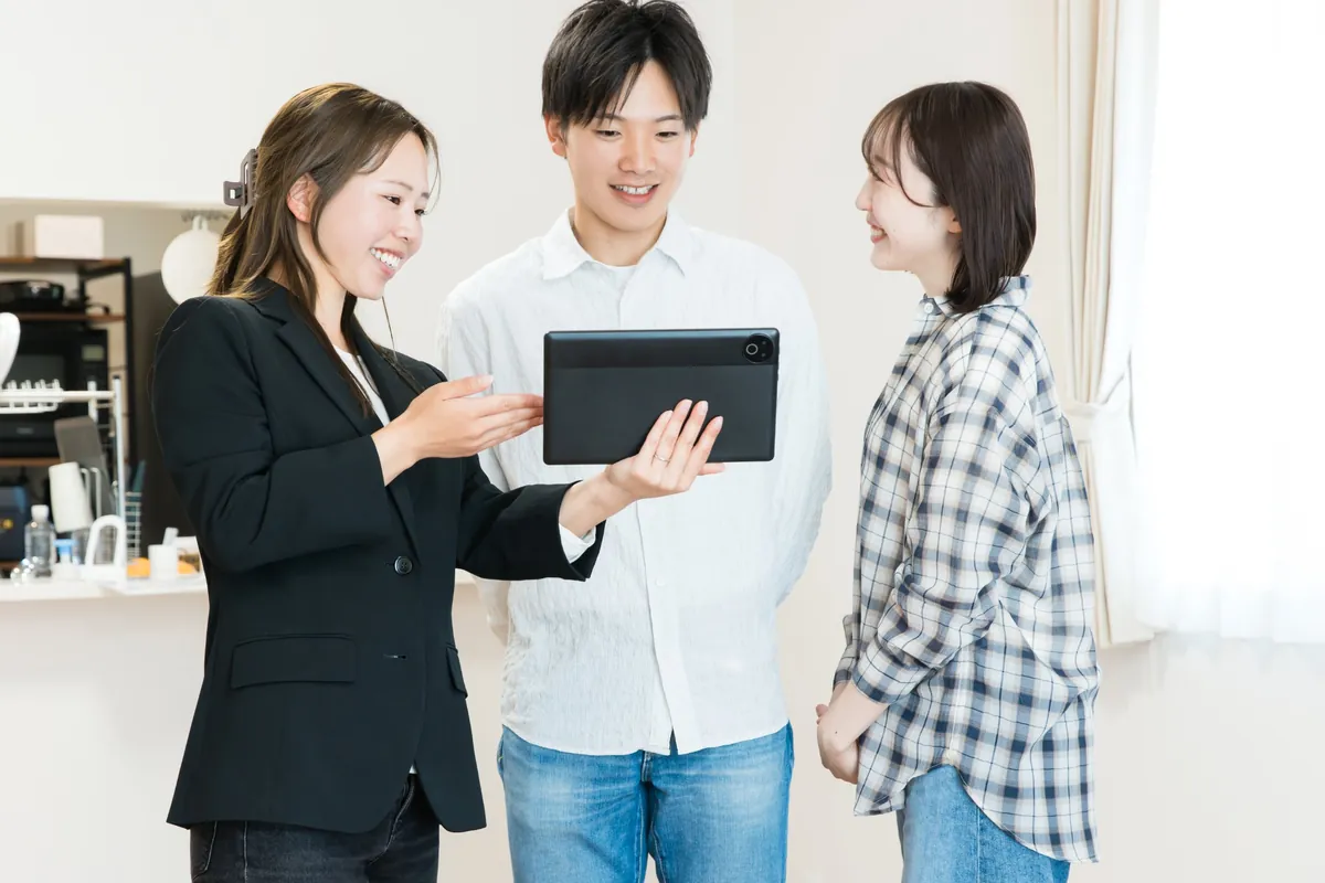 タブレットで物件をご紹介するスタッフとご夫婦