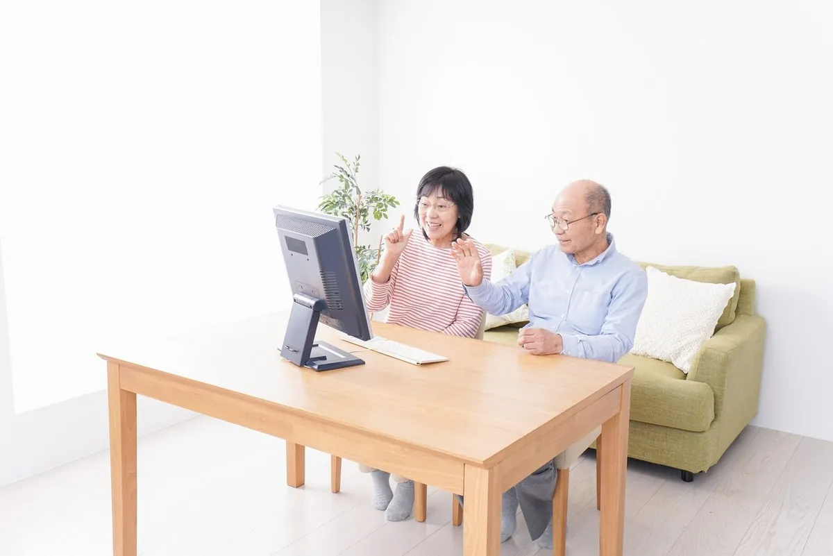 パソコンの画面に向かって話す年配のご夫婦