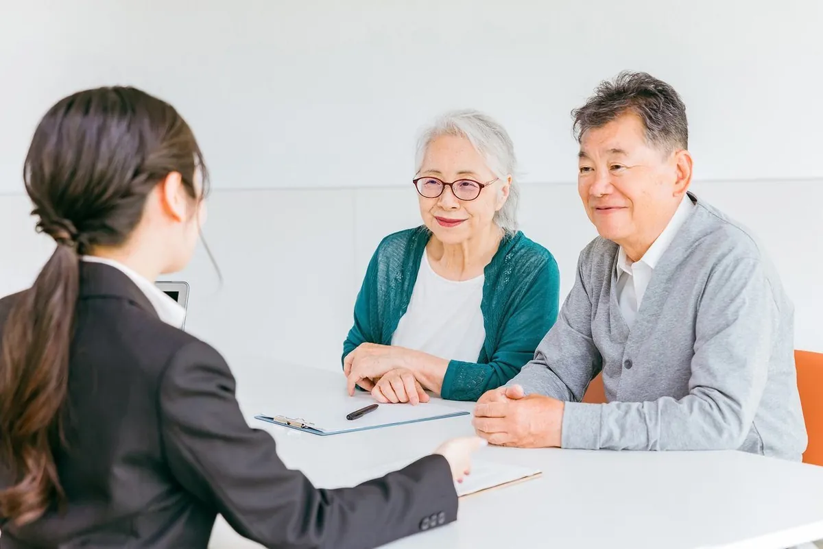 女性スタッフの説明を聞く年配のご夫婦