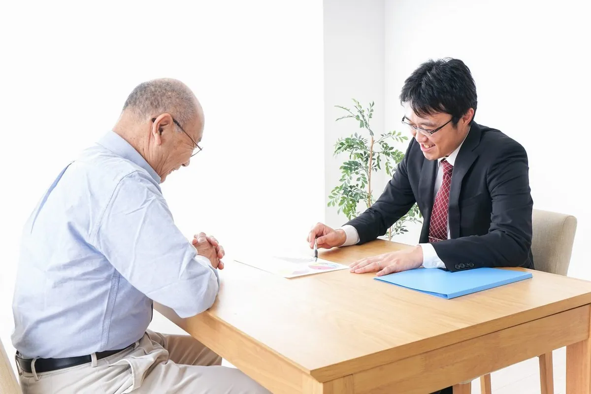 スタッフの説明を聞く年配の男性