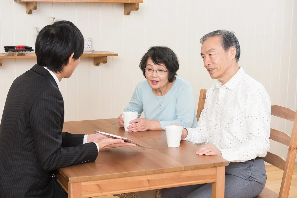 タブレットで説明するスタッフと年配のご夫婦