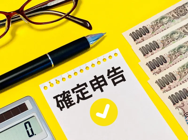 確定申告と書かれたメモと電卓、一万円札